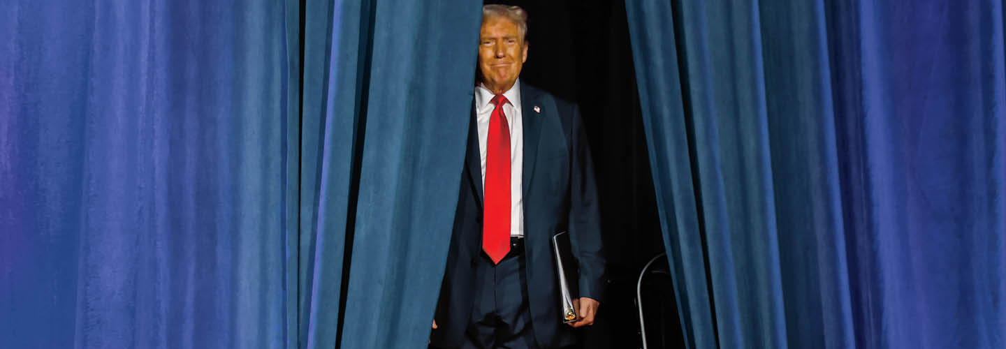 Image of Donald Trump walking out from behind blue curtains